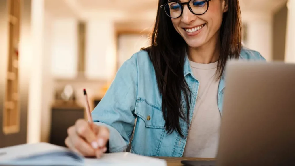 Imagem mulher escrevendo no caderno do artigo 10 maneiras para viver um 'Feliz Ano Novo'