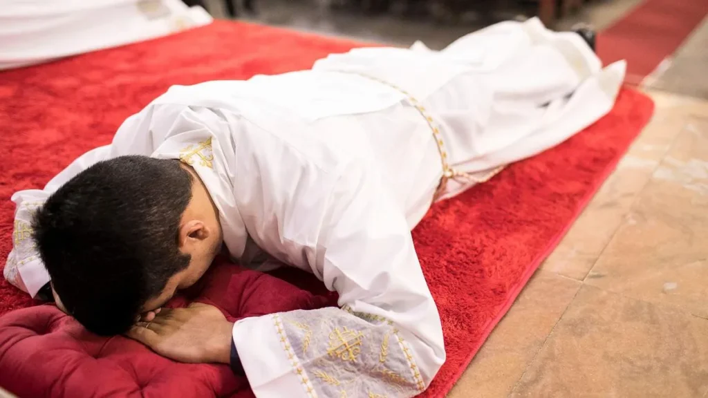 Vocacionado se deita durante a Ladainha dos Santos durante ordenação sacerdotal.