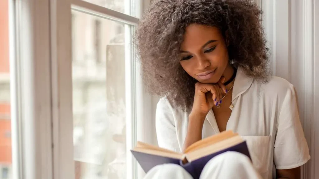 Imagem mulher lendo livro leitura do artigo Leituras de esperança: Como fortalecer minha fé em tempos difíceis?