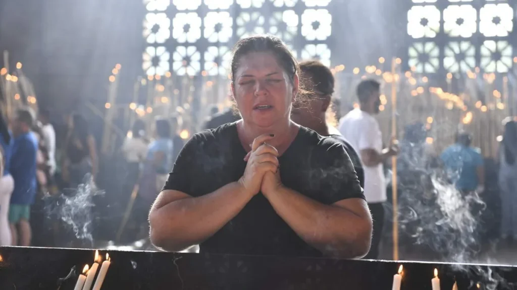 Imagem Devota rezando na Sala das Velas do artigo A programação do Dia de Finados no Santuário