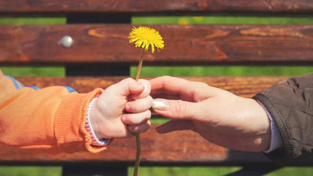 Imagem crianca entregando uma flor do artigo 15 ações simples de caridade que costumamos esquecer