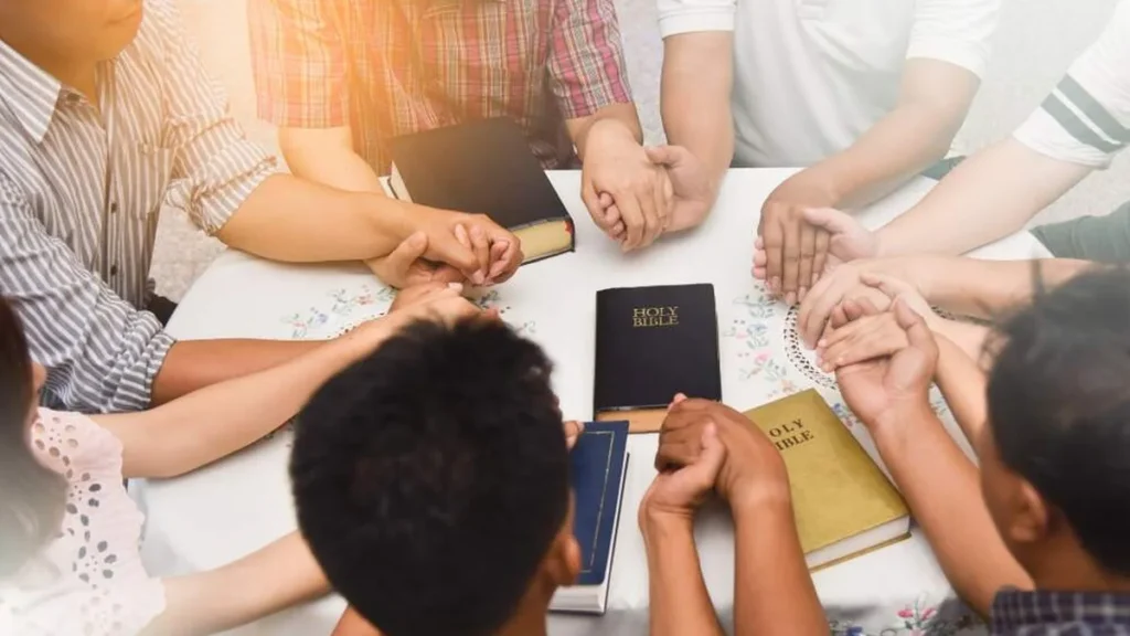 Grupo de pessoas rezando com Bíblias