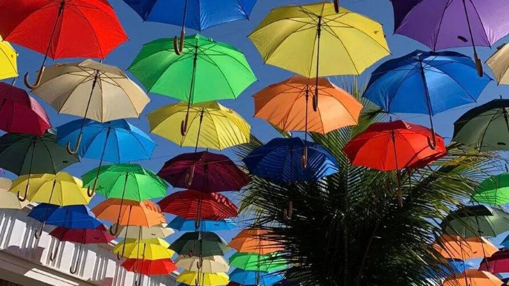 Imagem guarda chuvas coloridos cortado do artigo Notas, cores e flores: Cidade do Romeiro oferece atrações musicais ao vivo