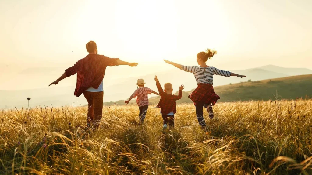 Imagem Familia feliz. Mae pai filhos na natureza ao por do sol do artigo Como posso ser um construtor da paz?