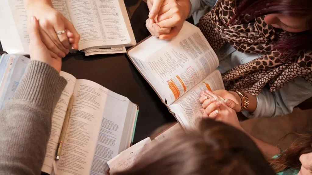 Imagem amigos lendo a biblia juntos e de maos dadas do artigo 5 ensinamentos da Bíblia para você ser um bom amigo!