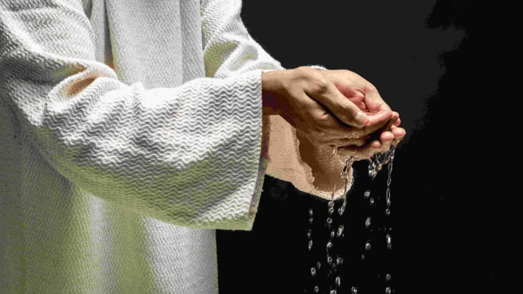 Imagem maos de Jesus com agua do batismo do artigo Voltei para a Igreja Católica: É necessário um novo batismo?