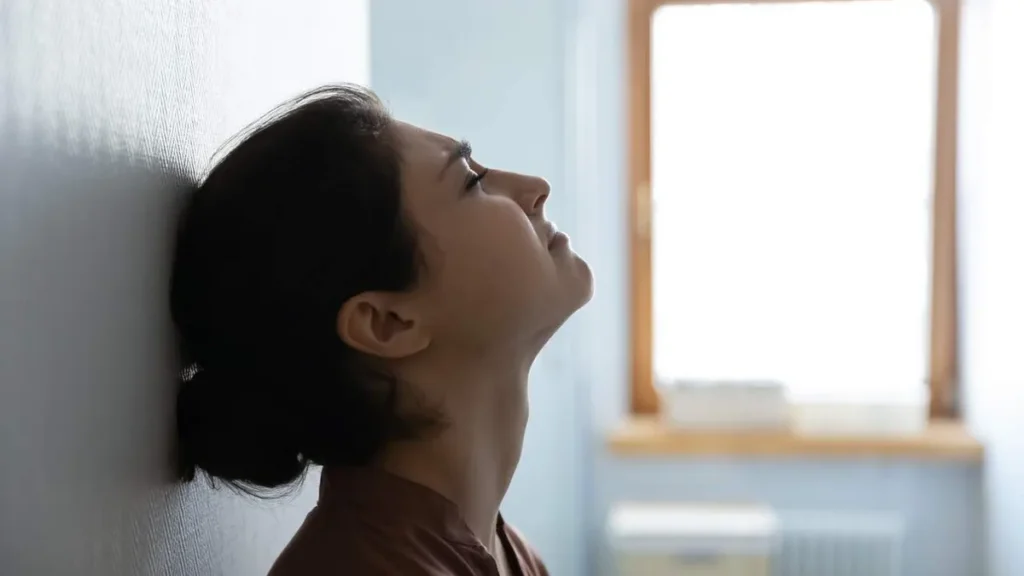 Imagem mulher aflita encostada na parede do artigo O que fazer quando estou com medo?