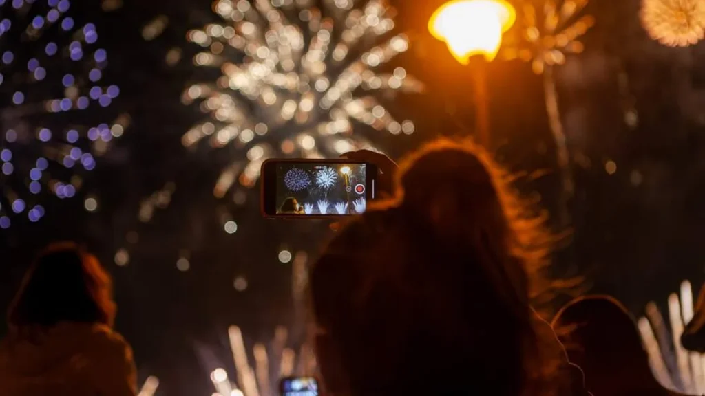 Imagem pessoa tirando foto de fogos do artigo Como fazer as promessas de ano novo darem certo?