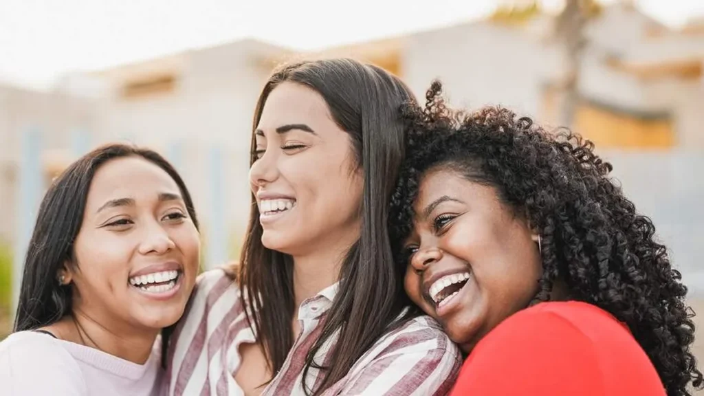 Imagem amigas se abracando e sorrindo do artigo Quer dizer obrigado a alguém? Envie essa playlist! 🎵