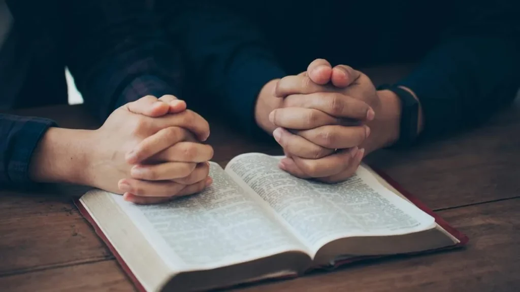 Imagem maos de um casal orando sobre a biblia do artigo Posso dar “um tempo” no meu casamento?