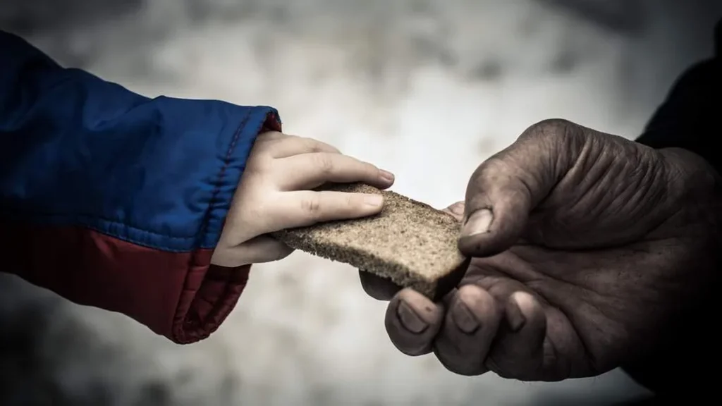Imagem crianca da ao homem um pedaco de pao de centeio do artigo Qual o objetivo da Campanha da Fraternidade 2023?