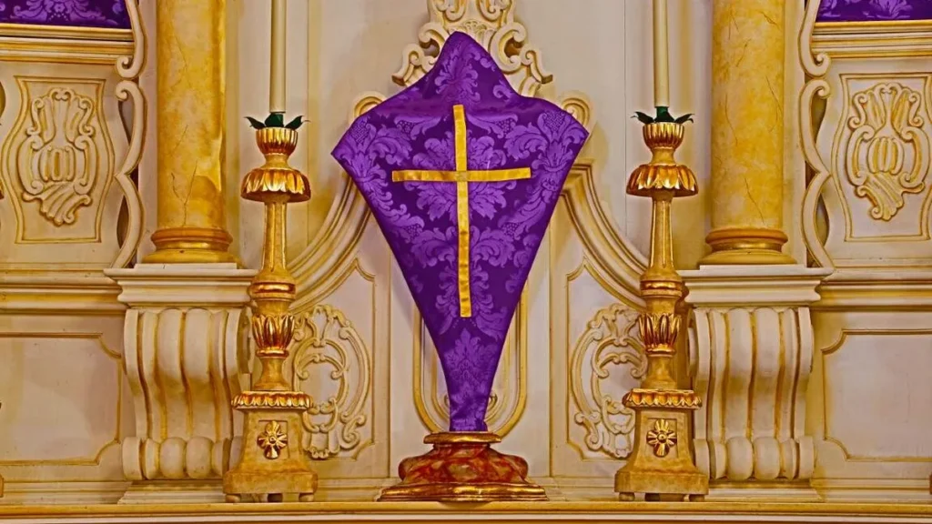 Imagem cruz coberta com um pano roxo sobre o altar do artigo Por que algumas igrejas cobrem as imagens na Quaresma?