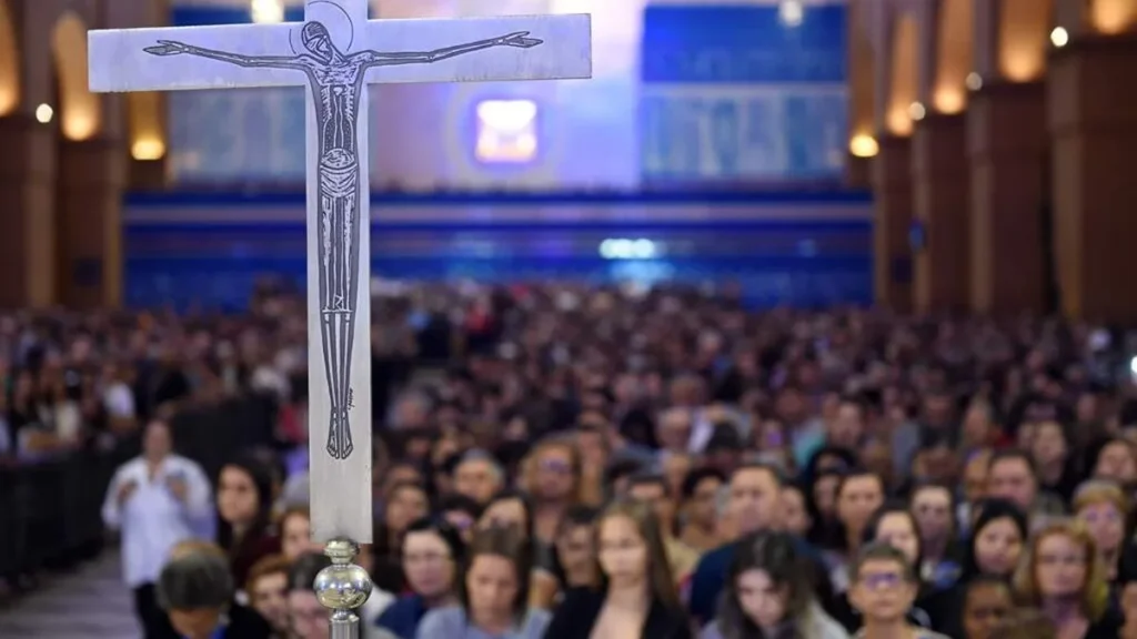 Imagem Cruz com pessoas ao fundo do artigo Assumir a vocação da cruz para encontrar a redenção