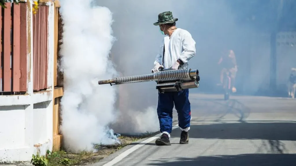 Homem passa fumacê de dengue em fachada de casa