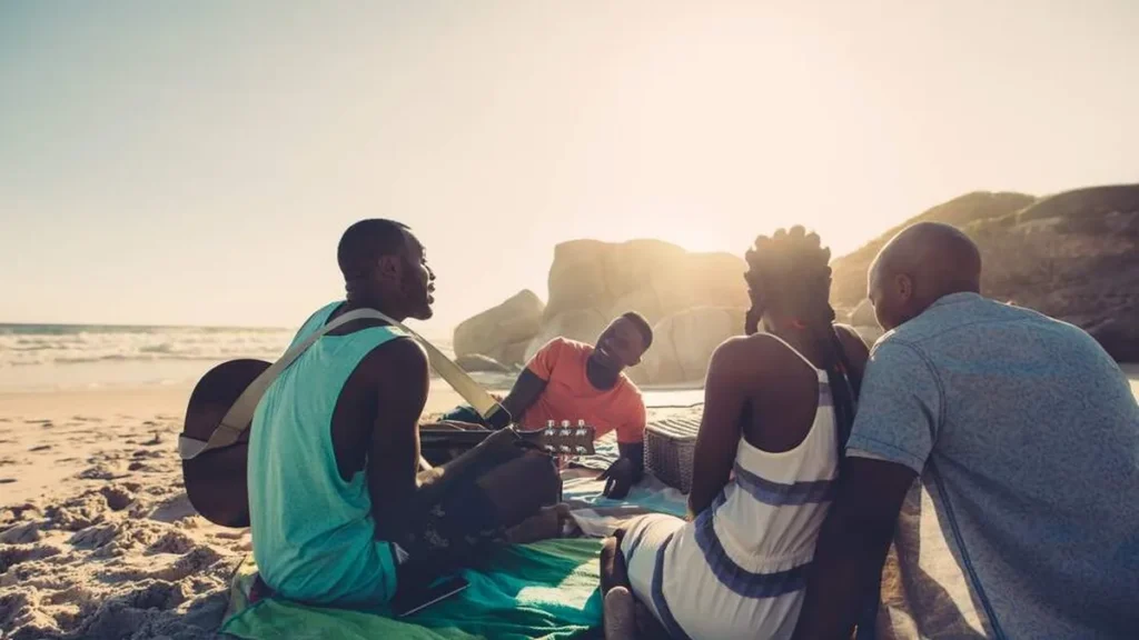 Jovens negros cantando juntos na praia