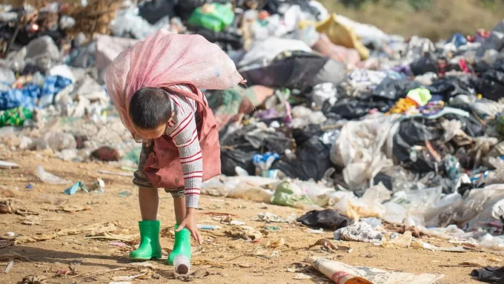 Criança em lixão catando lixo