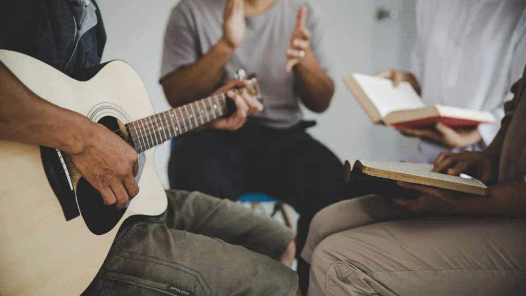 Imagem Maos tocando violao e fazendo home do artigo A importância da música na evangelização