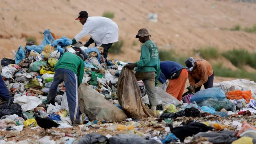 Imagem pessoas catando lixo no aterro sanitario do artigo A pobreza crônica no Brasil