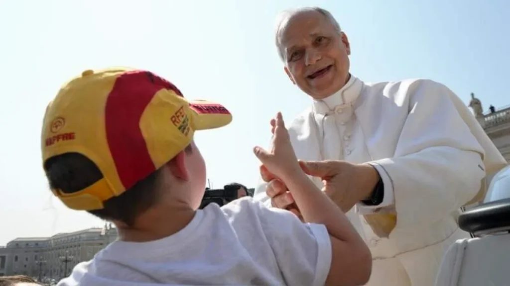 Imagem papa sorrindo para uma crianca do artigo Papa também tira férias. Você sabia?
