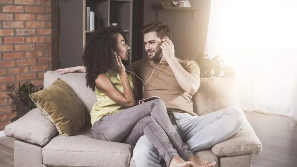 Casal juntos no sofá ouvindo música