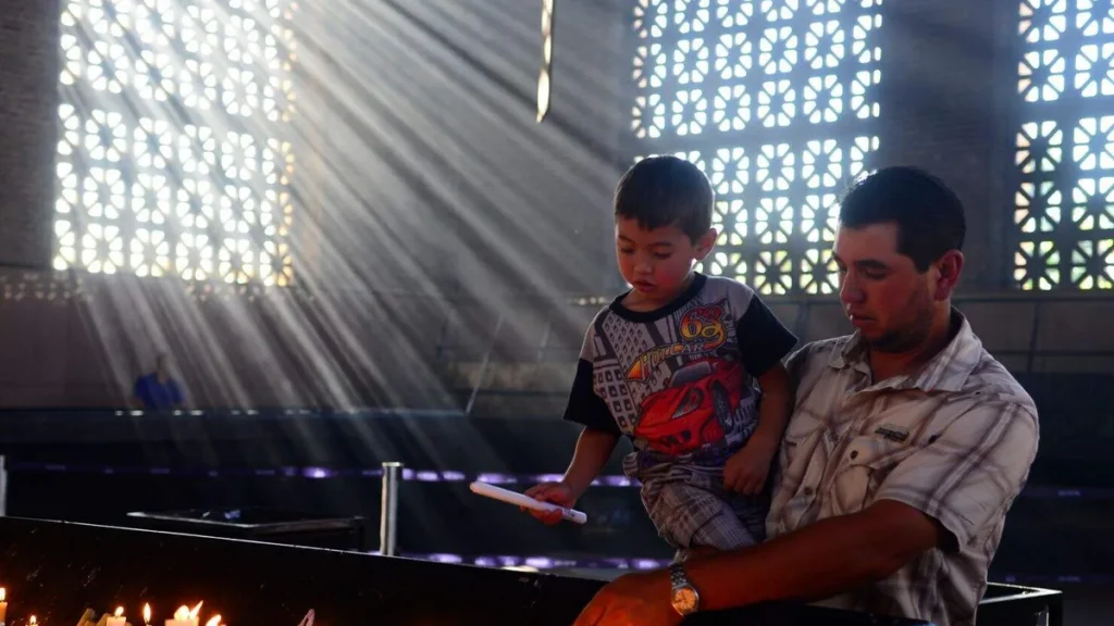 Imagem Pai e filho acendendo velas no Santuario do artigo Oração de São José para todos os pais