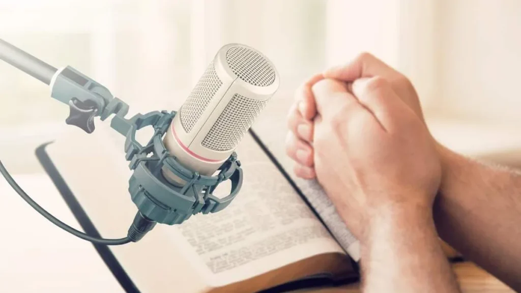 Imagem pessoa rezando o terco com a Biblia aberta proxima a um microfone do artigo Comunicação: expressão de comunhão