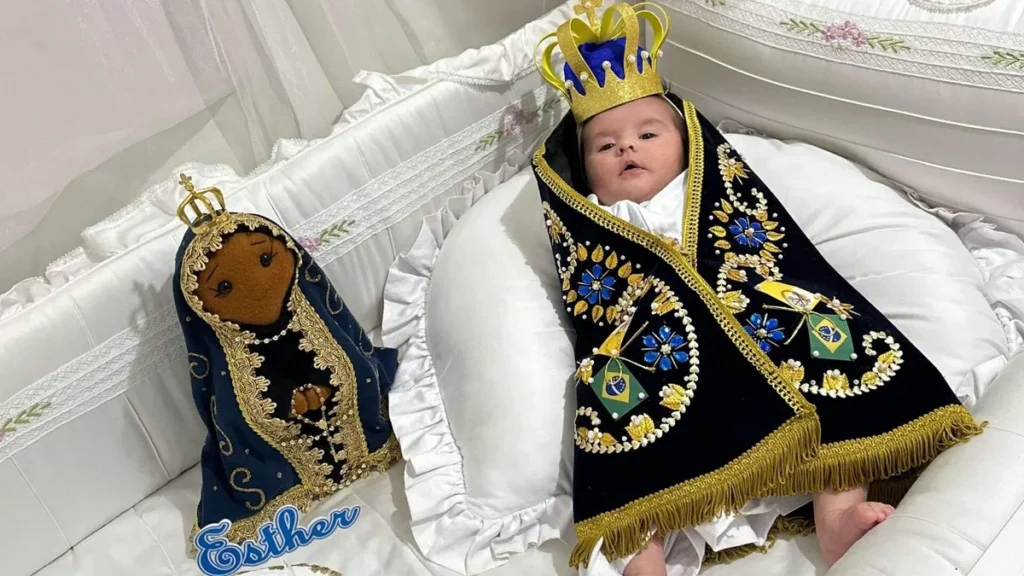 Imagem Bebe vestida com mando azul de Nossa Senhora Aparecida do artigo Família celebra vida de bebê com tema inspirado em Nossa Senhora