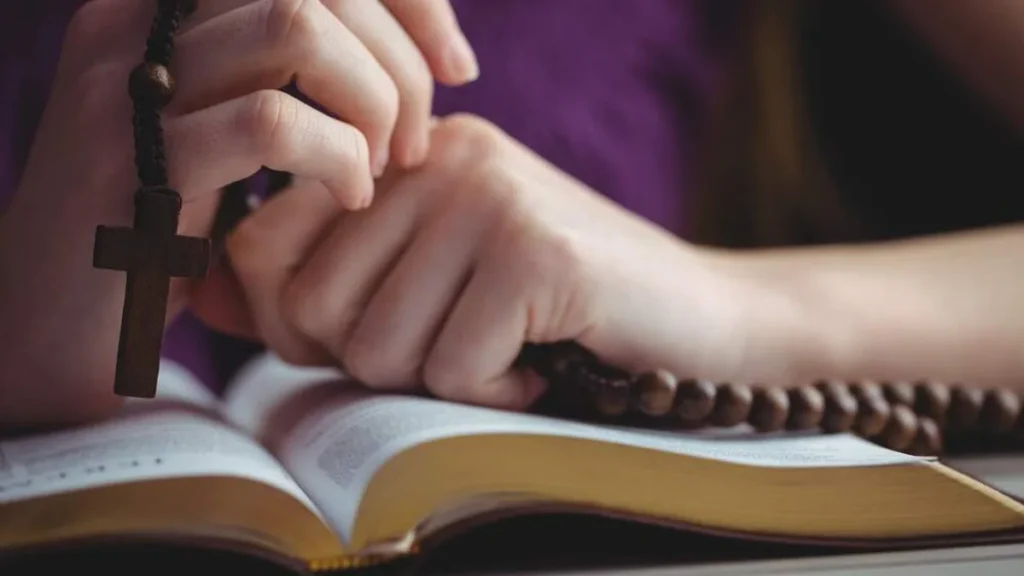 Imagem mulher lendo e rezando o terco do artigo Aprenda a rezar o Terço de forma significativa com 4 livros