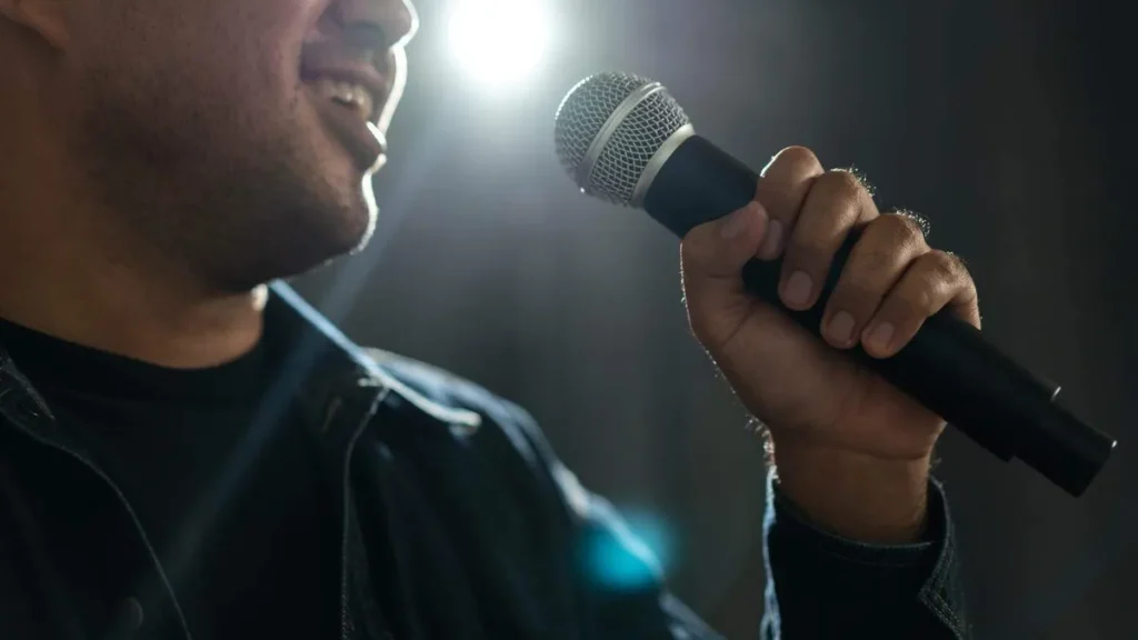 Imagem Homem segurando um microfone cantando do artigo Dicas para se tornar cantor católico e evangelizar por meio da musica