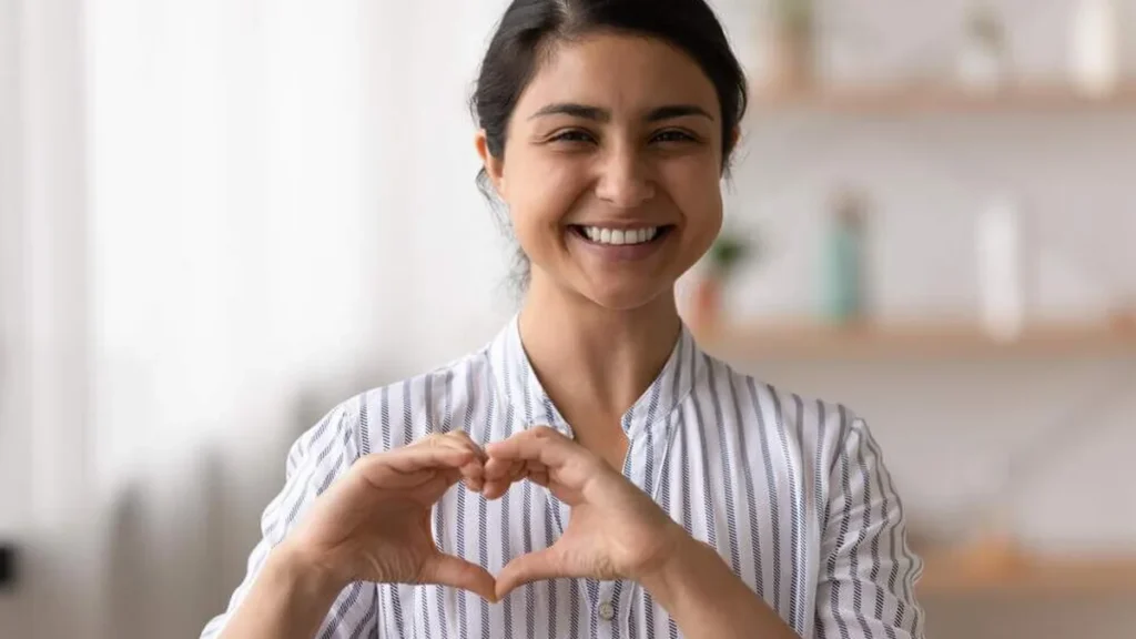 Imagem Mulher feliz faz gesto coracao com as maos do artigo Vocação: solteiro e comprometido!