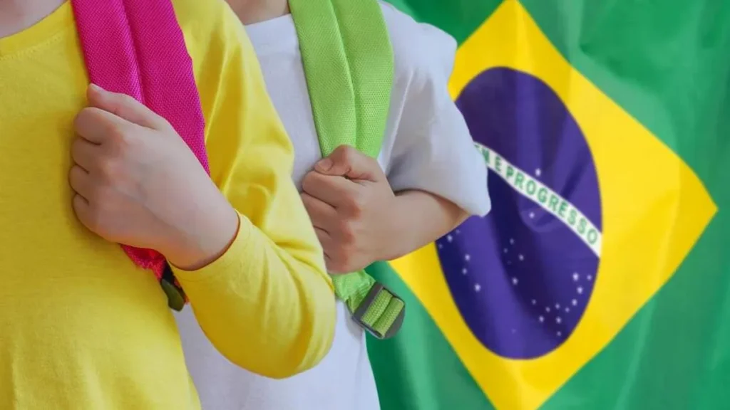 Imagem criancas com mochilas nas costas e bandeira do brasil ao fundo do artigo Crianças brasileiras participam de encontro com o Papa Francisco