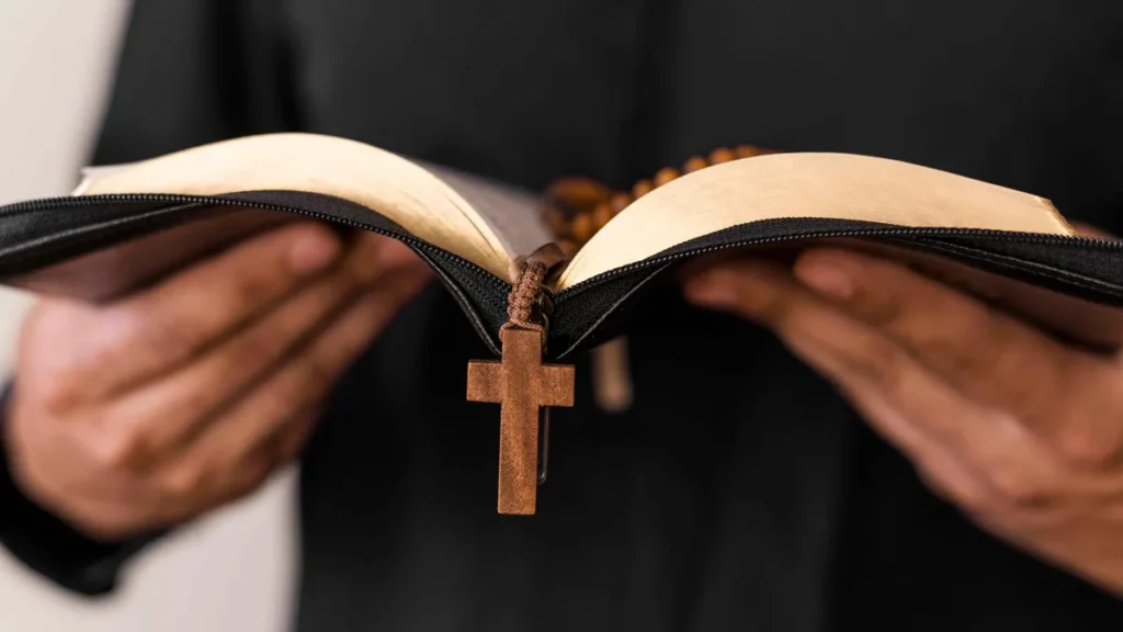 Imagem padre segurando biblia e terco de madeira do artigo Comissão da CNBB promove Seminário de Iniciação à Vida Cristã para sacerdotes