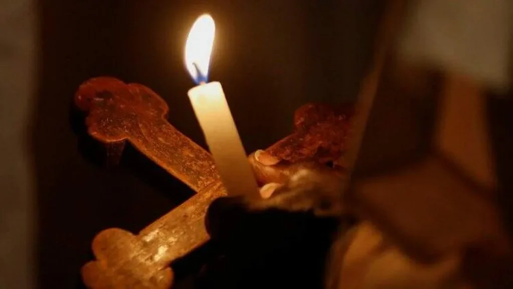 Imagem pessoa negra segura vela e cruz do artigo Burkina Faso busca no ecumenismo a saída para problemas no país
