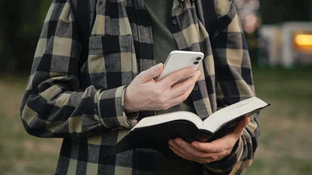 Imagem jovem com biblia e celular na mao do artigo Arquidiocese de Goiânia incentiva a Lectio Divina na Quaresma