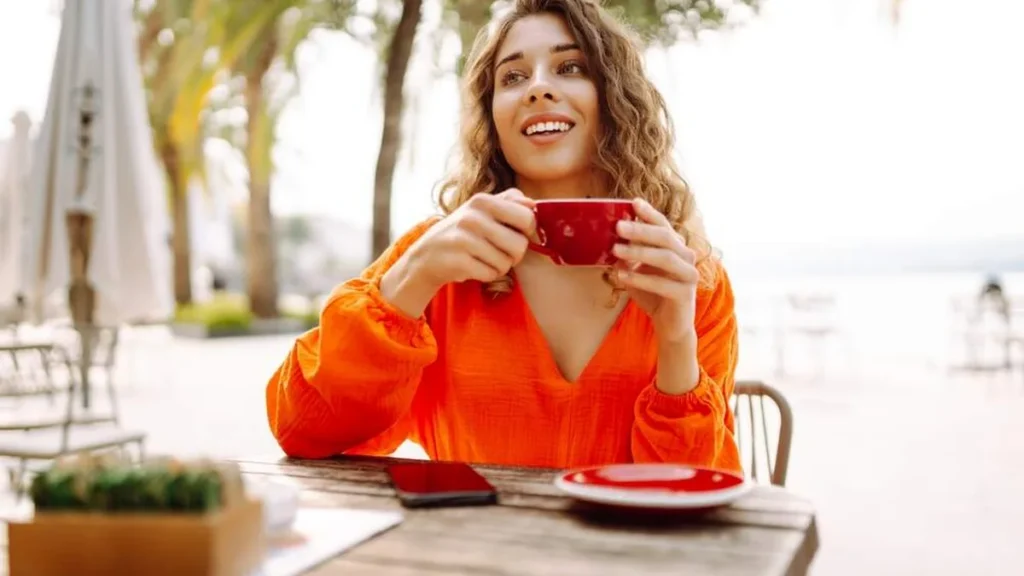 Imagem Mulher feliz tomando cafe do artigo Abra uma porta para o seu bem-estar e sua felicidade