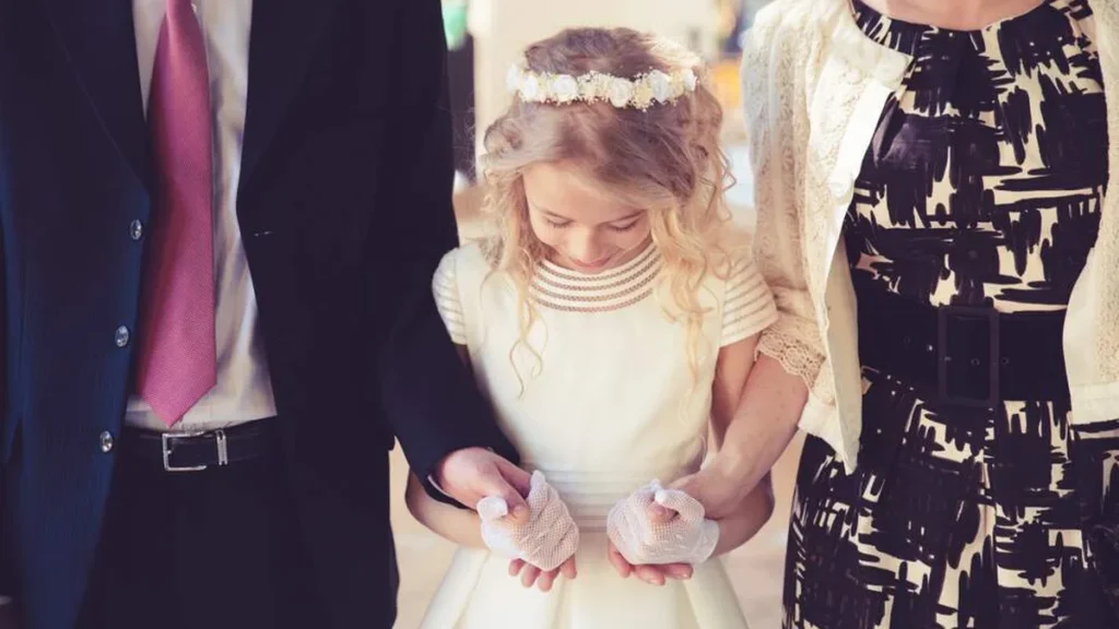 Imagem casal segurando as maos de uma menina do artigo 6 afirmações católicas para as famílias