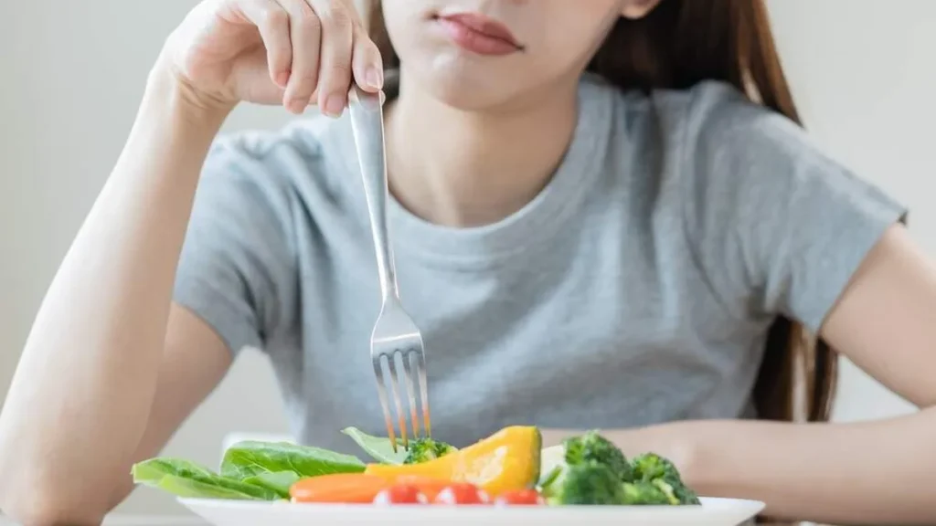 Imagem Mulher com depressao se alimentando do artigo Como a alimentação pode ajudar a diminuir os sintomas depressivos?