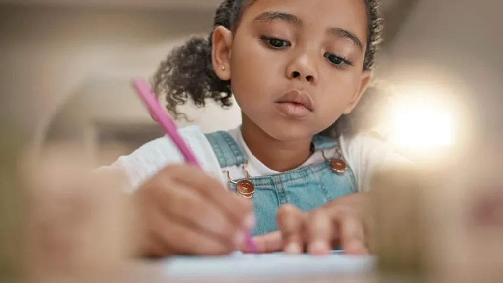 Imagem crianca escrevendo em folha de papel do artigo Semana Nacional da Família: Baixe atividades para as crianças