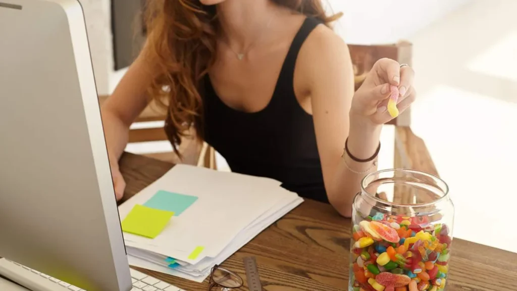 Imagem Mulher comendo doce do artigo Exagerei na quantidade de doce no meu dia. O que fazer?