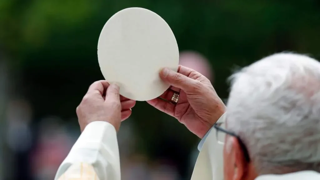 Imagem Padre segurando a hostia consagrada levantada do artigo Alimento divino: a Eucaristia é o Pão que sustenta a vida espiritual