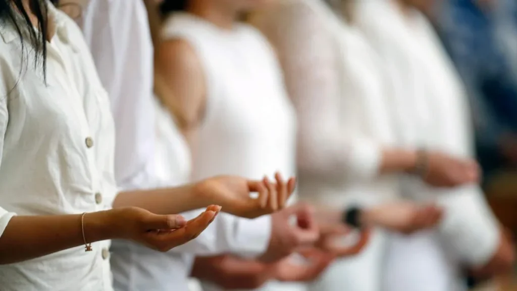 Imagem pessoas com camisas brancas em igreja rezando do artigo Após a Crisma, não se despeça da Igreja!