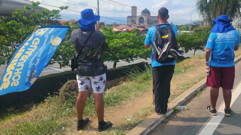 Imagem Romeiros observam o Santuario do artigo Basílicas de Aparecida são proclamadas igrejas do Jubileu da Esperança