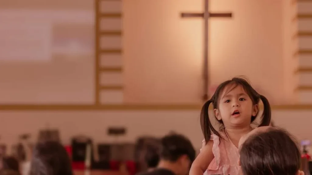 Criança e mãe durante a Celebração da Santa Missa