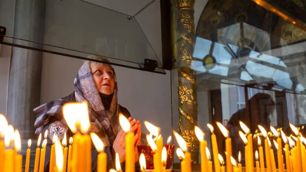 Imagem mulher rezando em igreja na ucrania do artigo Perseguição aos cristãos piora em todo o mundo, diz relatório da ACN