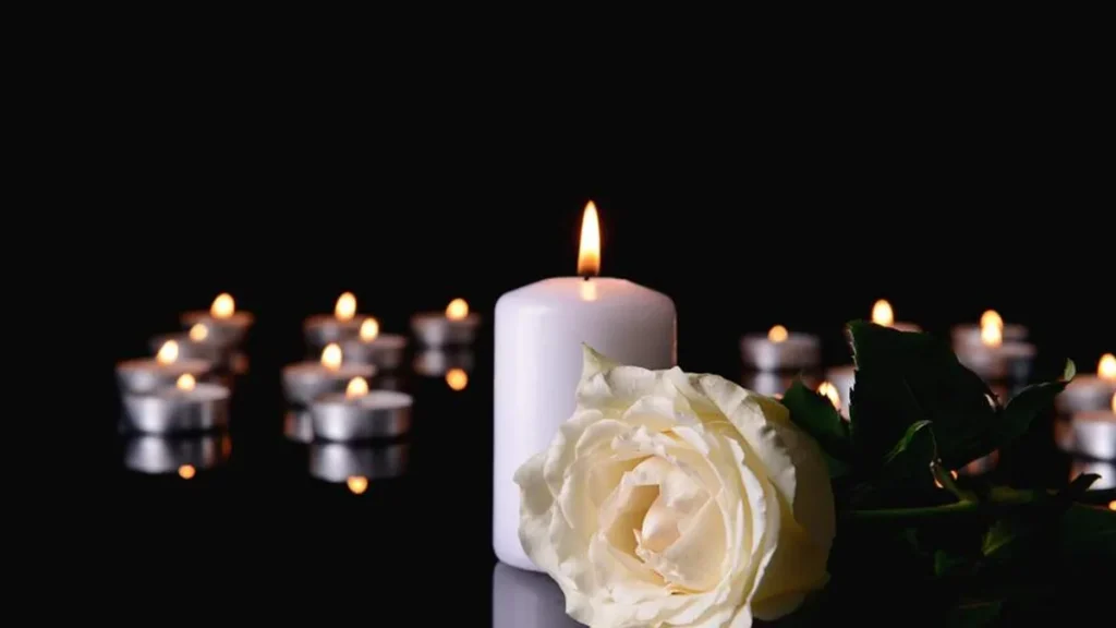 Imagem velas acessas com rosas brancas do artigo Indulgência plenária do Dia de Finados: como conseguir?