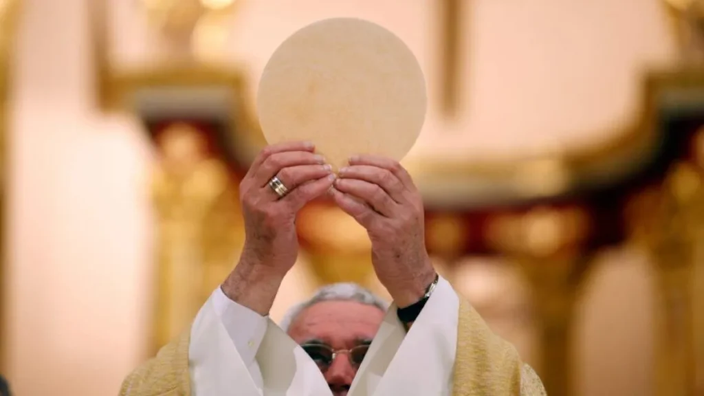 Imagem Padre com a hostia erguida no momento de consagracao do artigo Dogmas da Igreja: a Eucaristia é verdadeiro Sacramento instituído por Cristo