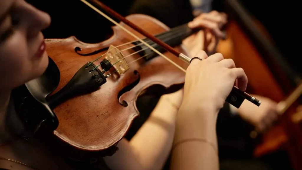Imagem mulher tocando violino do artigo Celebre o Dia do Músico com a Orquestra do PEMSA