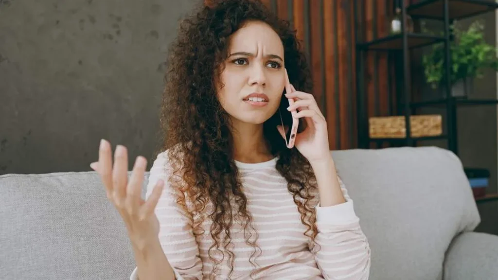 Imagem mulher sentada reclamando ao telefone do artigo Por que reclamamos tanto?