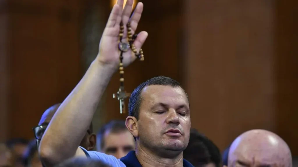 Imagem homem rezando com o terco na mao estendida do artigo Terço dos Homens transforma a espiritualidade masculina