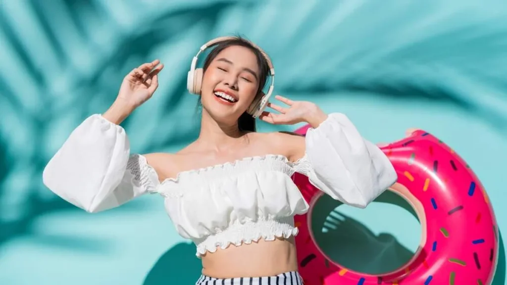 Imagem Mulher ouvindo musica no verao do artigo Vem Verão! Aproveite a estação mais querida do ano com a Pop